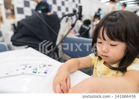 一位日本小女孩在工作坊專心製作貼紙工藝品。 141866436