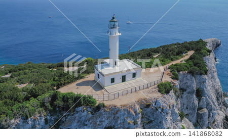 Drone view of white lighthouse at Cape Lefkatas standing on dramatic white limestone cliff edge over Ionian sea in Lefkada Greece for travel destination backdrop Drone view of white lighthouse at Cape Lefkatas standing on dramatic white limestone cliff edge over Ionian sea in Lefkada Greece for travel destination backdrop 141868082