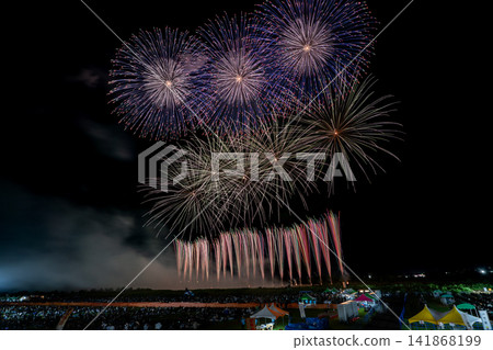 淡藍色的煙火在夜空中呈水平線狀綻放。 淡藍色的煙火在夜空中呈水平線狀綻放。 141868199