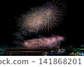 A scene from a fireworks festival, bustling with food stalls and spectators. 141868201