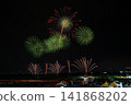 Green light spreads as fireworks are launched and the audience 141868202
