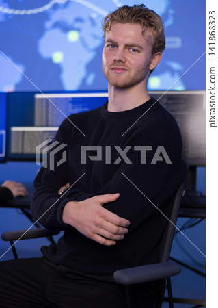 Confident young professional male in control room monitoring systems and data Confident young professional male in control room monitoring systems and data 141868323