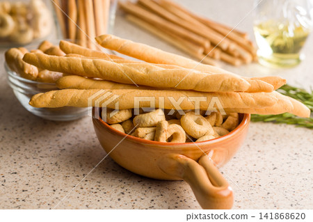 Italian Breadsticks And Taralli Snack In Bowl On Kitchen Counter With Olive Oil Italian Breadsticks And Taralli Snack In Bowl On Kitchen Counter With Olive Oil 141868620