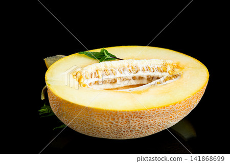 Organic cantaloupe melon slice with green basil on dark reflective surface Organic cantaloupe melon slice with green basil on dark reflective surface 141868699