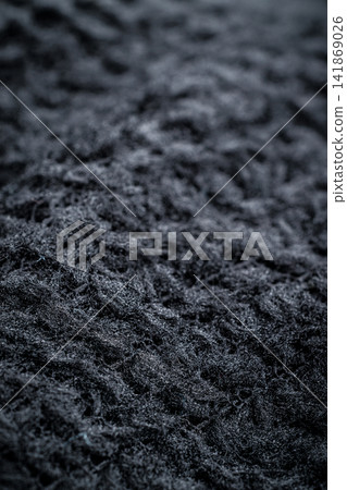 The fabric of black fleece, a synthetic knit with a soft, fluffy texture The fabric of black fleece, a synthetic knit with a soft, fluffy texture 141869026