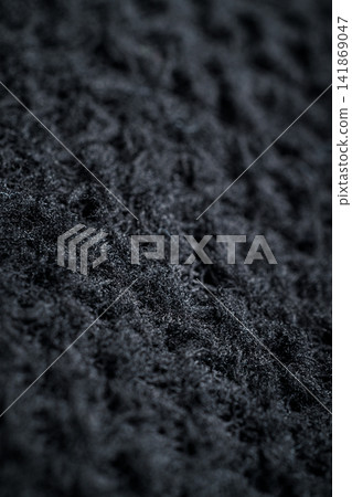 The fabric of black fleece, a synthetic knit with a soft, fluffy texture The fabric of black fleece, a synthetic knit with a soft, fluffy texture 141869047