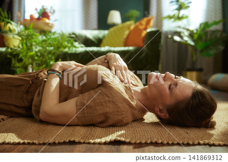 Woman Practicing Mindful Breathing on a Woven Mat at Home Woman Practicing Mindful Breathing on a Woven Mat at Home 141869312