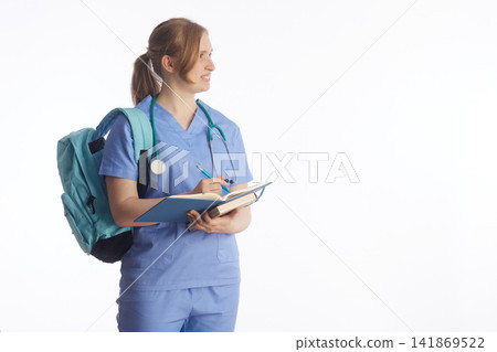 Aspiring Nurse with Notebook and Backpack Looking Aside Aspiring Nurse with Notebook and Backpack Looking Aside 141869522