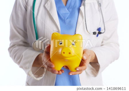 Healthcare Worker Holding a Piggy Bank with Both Hands Healthcare Worker Holding a Piggy Bank with Both Hands 141869611