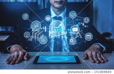 A business professional examines digital trends on a tablet, surrounded by a visual interface displaying graphs and analytics symbols, highlighting innovative technology solutions. Sigmoid A business professional examines digital trends on a tablet, surrounded by a visual interface displaying graphs and analytics symbols, highlighting innovative technology solutions. Sigmoid 141869669