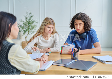 Social worker or teacher listening to teenage students 141869822
