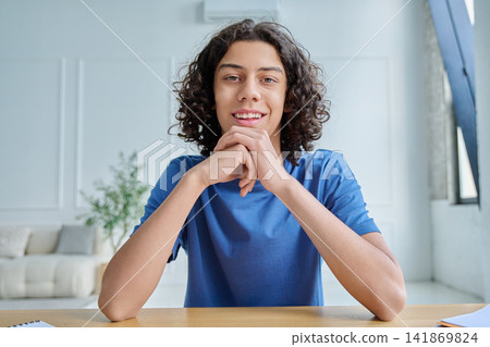Smiling teen boy listening during online class Smiling teen boy listening during online class 141869824