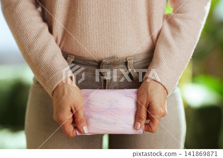 Woman Holding Menstrual Pad at Waist Woman Holding Menstrual Pad at Waist 141869871
