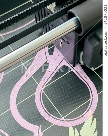 A close up view of a three d printer nozzle creating intricate pink plastic filament shapes A close up view of a three d printer nozzle creating intricate pink plastic filament shapes 141870021