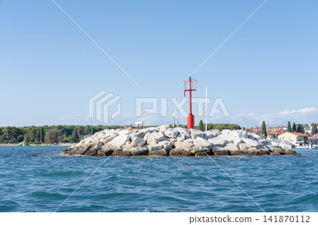 A large metal green lighthouse on a rock in the sea, near Cape Punta Planka in Croatia.20.07.2026 A large metal green lighthouse on a rock in the sea, near Cape Punta Planka in Croatia.20.07.2026 141870112