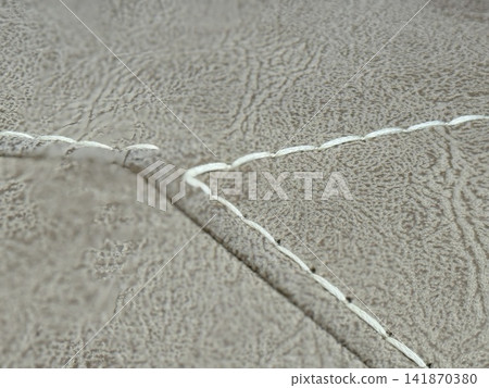 Closeup of beige leather texture with white stitching, ideal for background or design projects Closeup of beige leather texture with white stitching, ideal for background or design projects 141870380