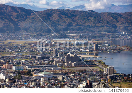 A townscape spread along the shores of Lake Suwa, with the autumn mountain range as a backdrop. A townscape spread along the shores of Lake Suwa, with the autumn mountain range as a backdrop. 141870493