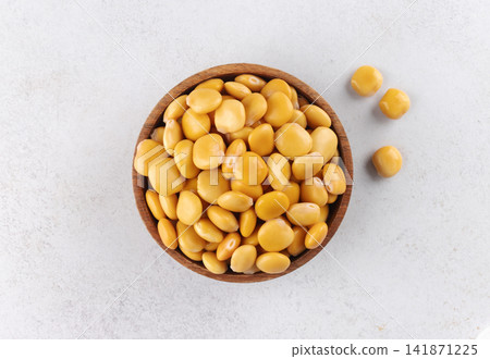 Pickled yellow lupin beans on a white background. High protein plant food. Top view Pickled yellow lupin beans on a white background. High protein plant food. Top view 141871225