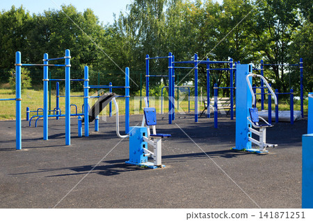 Municipal sports ground with exercise equipment in a residential area. Various sports equipment on a sports ground Municipal sports ground with exercise equipment in a residential area. Various sports equipment on a sports ground 141871251