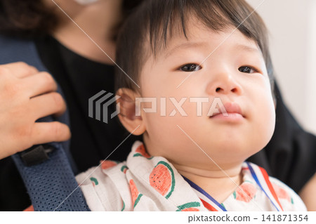 一名身穿西瓜圖案甚平的日本男嬰被放在嬰兒背帶裡參加節慶活動。 141871354