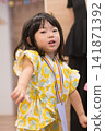 身穿向日葵圖案甚平(日本傳統夏季服裝)的日本女孩正在參加夏季祭典活動。 身穿向日葵圖案甚平(日本傳統夏季服裝)的日本女孩正在參加夏季祭典活動。 141871392