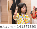 身穿向日葵圖案甚平(日本傳統夏季服裝)的日本女孩正在參加夏季祭典活動。 身穿向日葵圖案甚平(日本傳統夏季服裝)的日本女孩正在參加夏季祭典活動。 141871393
