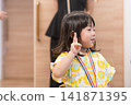 身穿向日葵圖案甚平(日本傳統夏季服裝)的日本女孩正在參加夏季祭典活動。 身穿向日葵圖案甚平(日本傳統夏季服裝)的日本女孩正在參加夏季祭典活動。 141871395