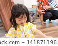 身穿向日葵圖案甚平(日本傳統夏季服裝)的日本女孩正在參加夏季祭典活動。 身穿向日葵圖案甚平(日本傳統夏季服裝)的日本女孩正在參加夏季祭典活動。 141871396