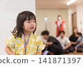 身穿向日葵圖案甚平(日本傳統夏季服裝)的日本女孩正在參加夏季祭典活動。 身穿向日葵圖案甚平(日本傳統夏季服裝)的日本女孩正在參加夏季祭典活動。 141871397