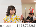 身穿向日葵圖案甚平(日本傳統夏季服裝)的日本女孩正在參加夏季祭典活動。 身穿向日葵圖案甚平(日本傳統夏季服裝)的日本女孩正在參加夏季祭典活動。 141871398