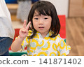 身穿向日葵圖案甚平(日本傳統夏季服裝)的日本女孩正在參加夏季祭典活動。 身穿向日葵圖案甚平(日本傳統夏季服裝)的日本女孩正在參加夏季祭典活動。 141871402