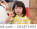 身穿向日葵圖案甚平(日本傳統夏季服裝)的日本女孩正在參加夏季祭典活動。 身穿向日葵圖案甚平(日本傳統夏季服裝)的日本女孩正在參加夏季祭典活動。 141871403