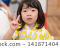 身穿向日葵圖案甚平(日本傳統夏季服裝)的日本女孩正在參加夏季祭典活動。 身穿向日葵圖案甚平(日本傳統夏季服裝)的日本女孩正在參加夏季祭典活動。 141871404
