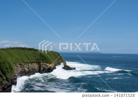 神奈川縣城島的岩石被洶湧的波濤和飛濺的浪花拍打著。 神奈川縣城島的岩石被洶湧的波濤和飛濺的浪花拍打著。 141871528