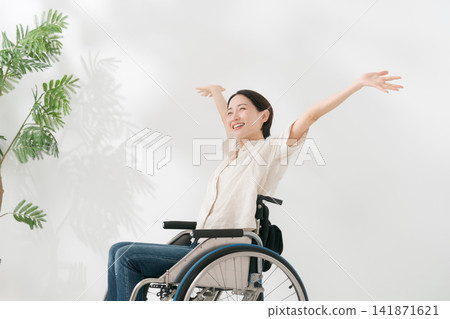 一位40多歲的女子坐在輪椅上,面帶微笑。 一位40多歲的女子坐在輪椅上,面帶微笑。 141871621