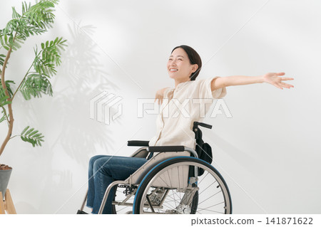 一位40多歲的女子坐在輪椅上,面帶微笑。 一位40多歲的女子坐在輪椅上,面帶微笑。 141871622