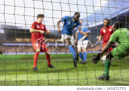 Blurred motion of player hitting ball in front of goalkeeper, player in motion attacking net to score goal. Goalie defending and blocking goal post by striker, football attack. Blurred motion of player hitting ball in front of goalkeeper, player in motion attacking net to score goal. Goalie defending and blocking goal post by striker, football attack. 141871755