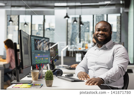 Portrait of african american man working on film montage editing, applying color grading and audio mixing for cinematic motion picture footage. Sound engineer doing audio sync, post production. 141871780