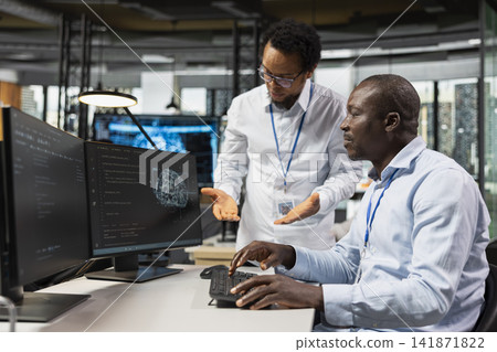 Manager supervising programmer running AI algorithms on PC in startup workspace. Supervisor overseeing work done by IT employee using artificial intelligence deep learning coding platform Manager supervising programmer running AI algorithms on PC in startup workspace. Supervisor overseeing work done by IT employee using artificial intelligence deep learning coding platform 141871822