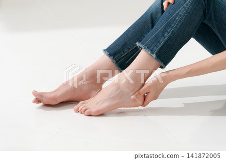 一個女人摸著自己的腳跟 一個女人摸著自己的腳跟 141872005