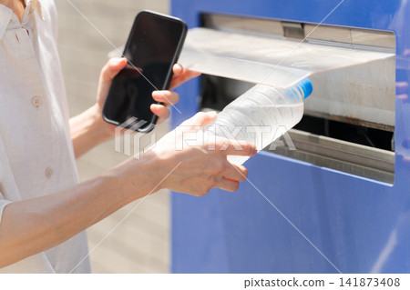 A woman buying water from a vending machine. A woman buying water from a vending machine. 141873408