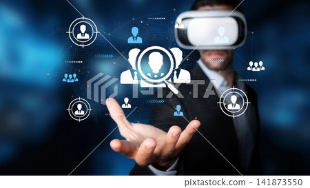 Businessman in Virtual Reality Headset Engaging with Digital Network of Users and Profiles in Futuristic Office Environment. Entropy Businessman in Virtual Reality Headset Engaging with Digital Network of Users and Profiles in Futuristic Office Environment. Entropy 141873550