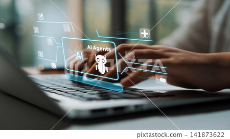 Hands typing on a laptop with holographic interface displaying AI agents in a modern workspace showcasing technology and innovation in artificial intelligence Gluon Hands typing on a laptop with holographic interface displaying AI agents in a modern workspace showcasing technology and innovation in artificial intelligence Gluon 141873622