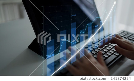Hands typing on a keyboard with digital financial graphs showing trends on a screen in a modern office setting, symbolizing data analysis and investment growth Copula Hands typing on a keyboard with digital financial graphs showing trends on a screen in a modern office setting, symbolizing data analysis and investment growth Copula 141874254