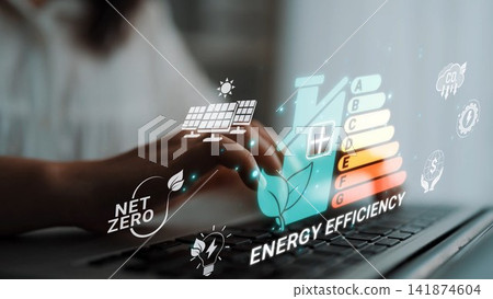 Digital representation of energy efficiency concepts featuring a person typing on a laptop with visual elements like solar panels, energy labels, and sustainability icons Sigmoid. 141874604