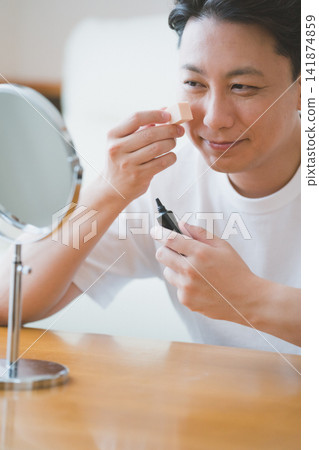 一名四十多歲的男子拿著一管BB霜。 一名四十多歲的男子拿著一管BB霜。 141874859