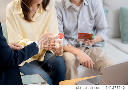 Asian young couple on sofa consulting with psychologist in living room at home. 141875242