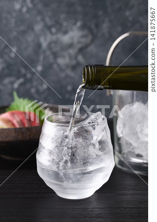 Pour shochu into a glass. Pour shochu into a glass. 141875667