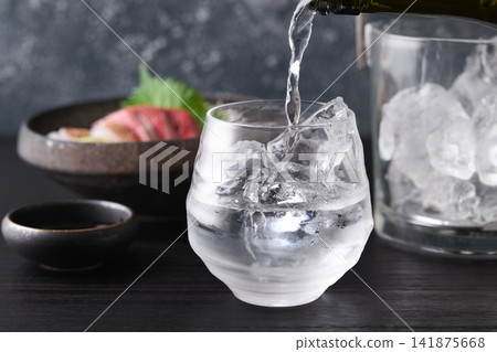 Pour shochu into a glass. Pour shochu into a glass. 141875668