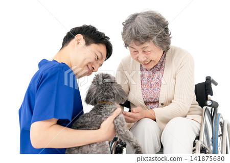 Senior woman in a wheelchair and therapy dog Senior woman in a wheelchair and therapy dog 141875680